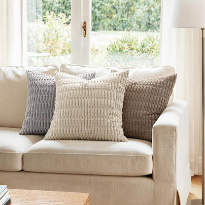 Cream, gray and taupe corduroy throw pillow covers on a beige couch